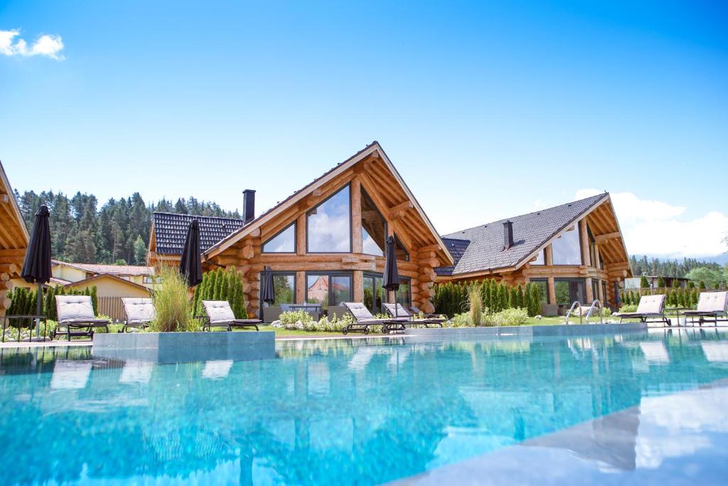 a log home with a swimming pool and a house at Alpina Luxury Chalets in Banya
