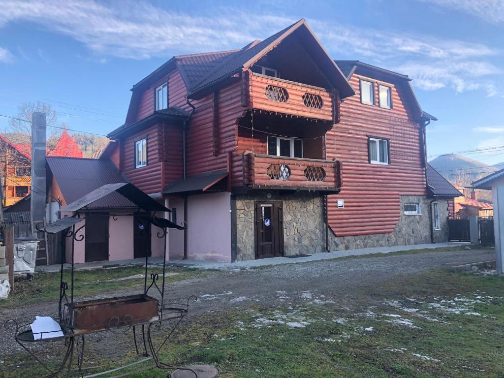 een groot houten huis met een bord ervoor bij Fayniy Motel in Tatariv