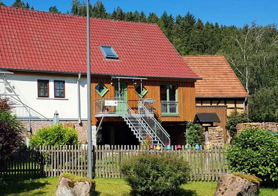 uma casa com um telhado vermelho e uma cerca em Sinnglück em Obersinn