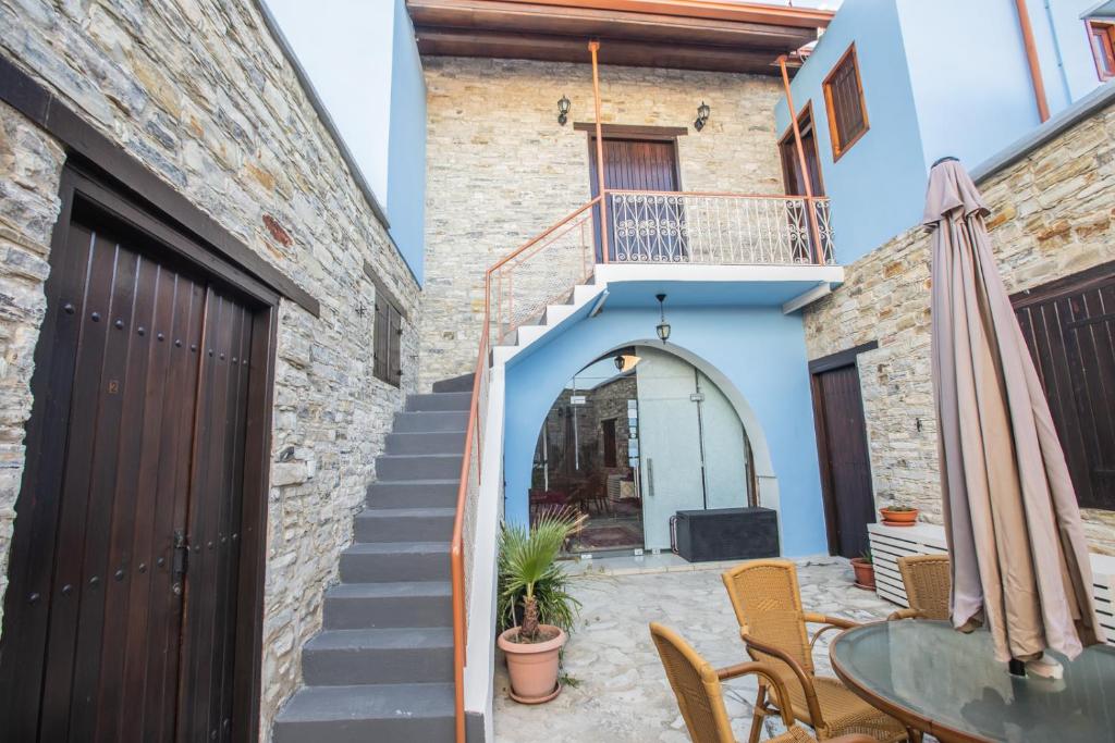 a patio in a house with a table and a staircase at Iosiphis Stonebuilt House in Pano Lefkara