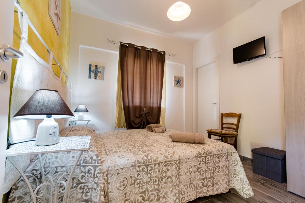 um quarto com uma cama e uma mesa com um candeeiro em Affittacamere L ' Oasi di Gino em San Lorenzo