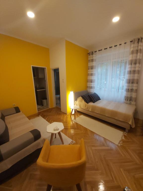 ein Wohnzimmer mit 2 Betten und einem Sofa in der Unterkunft IGNIM Apartment in Subotica