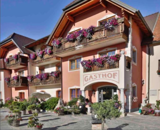 un grand bâtiment avec des boîtes de fleurs sur les balcons dans l'établissement Hotel Gasthof Familie Czepl, à Ernsthofen