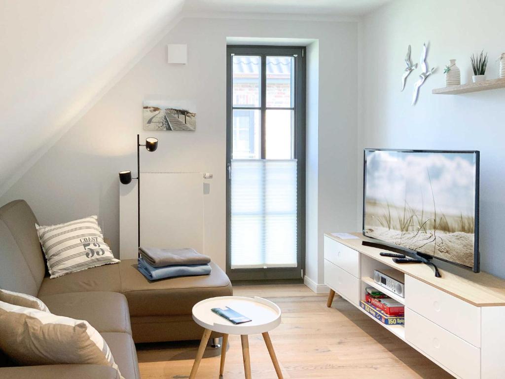 - un salon avec un canapé et une télévision dans l'établissement Strandglück, à Zingst