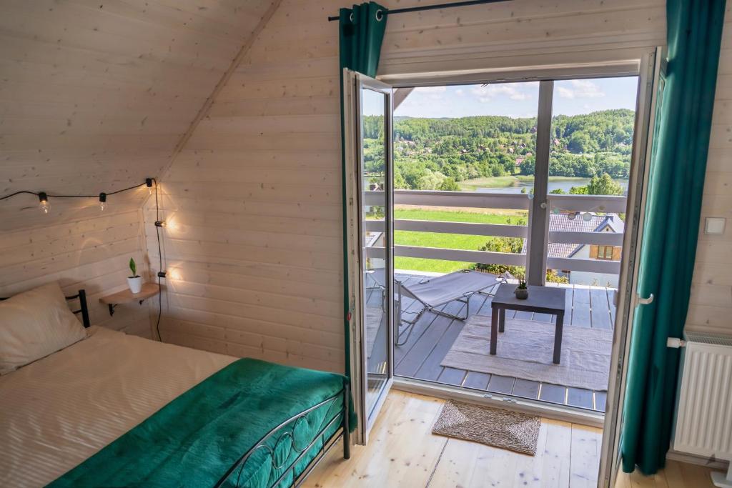 Pokój z łóżkiem i balkonem z widokiem na okolicę w obiekcie Easy Hill - domek na Kaszubach z sauną w mieście Pierszczewo