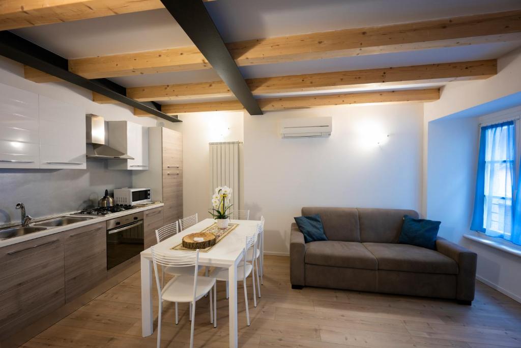 Una cocina y una sala de estar con una mesa y un sofá. en Appartamenti Rivantica, en Riva del Garda