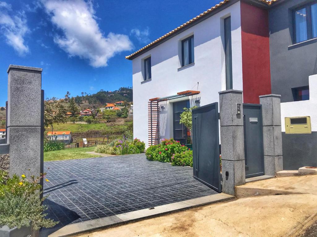 a white house with a gate and a driveway at Lucilia's House in Calheta