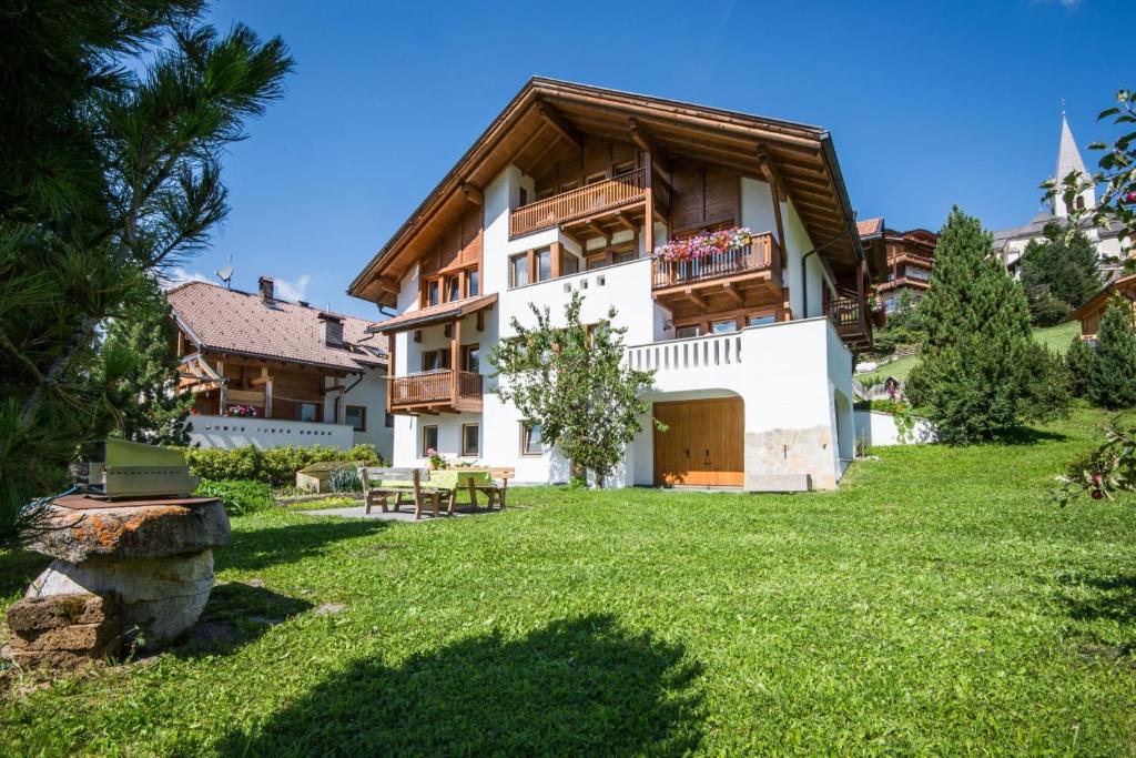 una grande casa con un prato verde davanti di Apartments Tino a La Valle