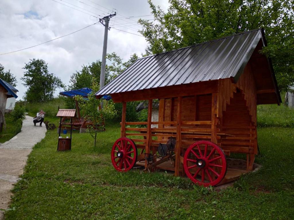 a wooden wagon with a tin roof on the grass at Vila Medo in Brdo