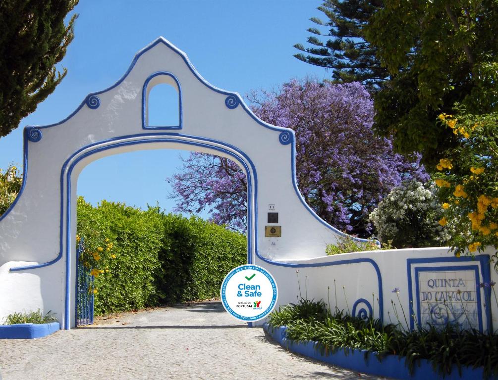 une porte menant à un jardin avec un panneau en face de celui-ci dans l'établissement Quinta do Caracol, à Tavira