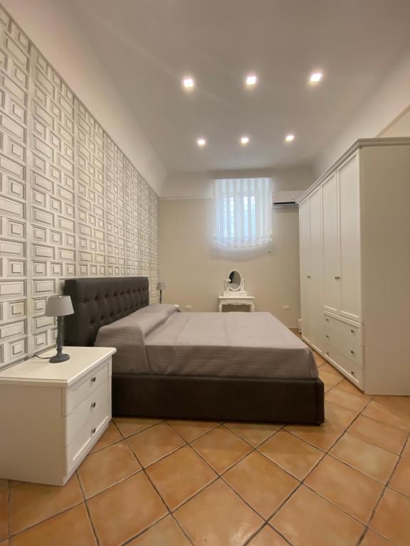 龐貝的住宿－La casa di Vesta，一间卧室配有一张大床和一个白色的橱柜