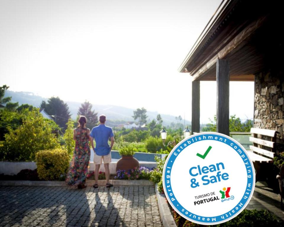 a man and a woman standing in front of a sign at Casa de Campo S. Torcato - Moradal - Turismo Espaco Rural in Estreito