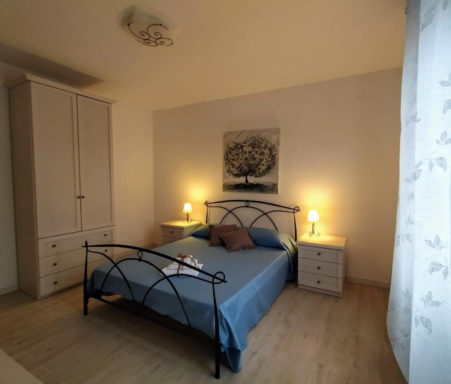 アルゲーロにあるB&B Alghero Mare Chiaroのベッドルーム1室(ベッド1台、ナイトスタンド2台、ランプ2つ付)