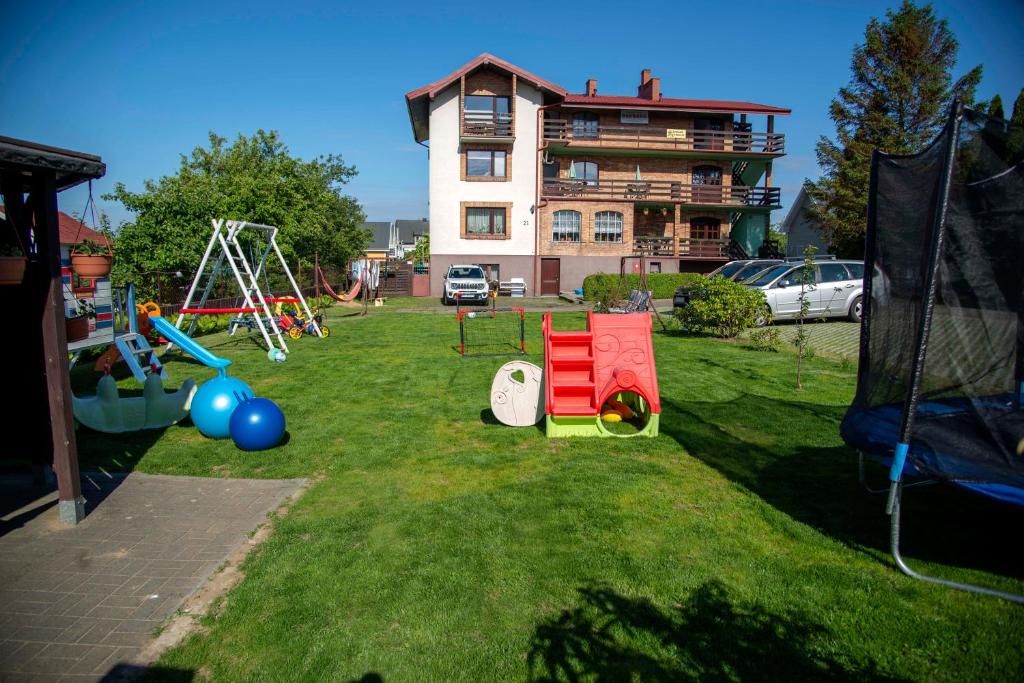 un patio con parque infantil frente a una casa en Dom Wczasowy "Barbara" en Władysławowo