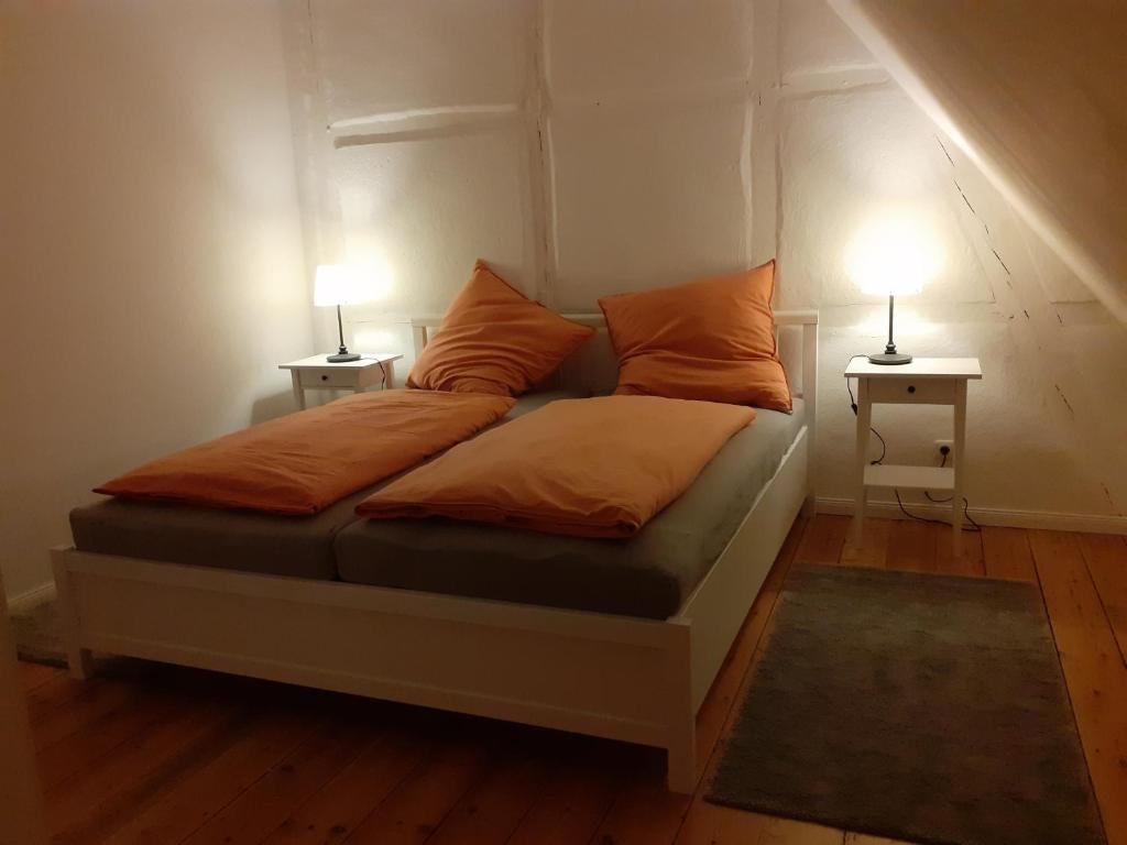 uma cama num quarto com duas lâmpadas nas mesas em Ferienwohnung ehemalige Revierförsterei "uns Lütt" em Kuhstorf