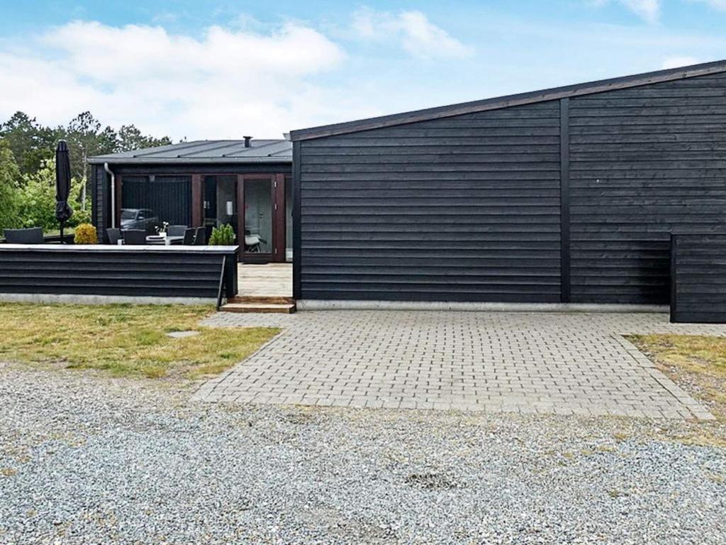 un edificio nero con un patio di fronte di 6 person holiday home in R m a Rømø Kirkeby