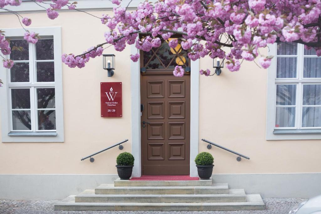 ein Haus mit einer braunen Tür mit rosa Blumen drauf in der Unterkunft Hotel am Großen Waisenhaus in Potsdam