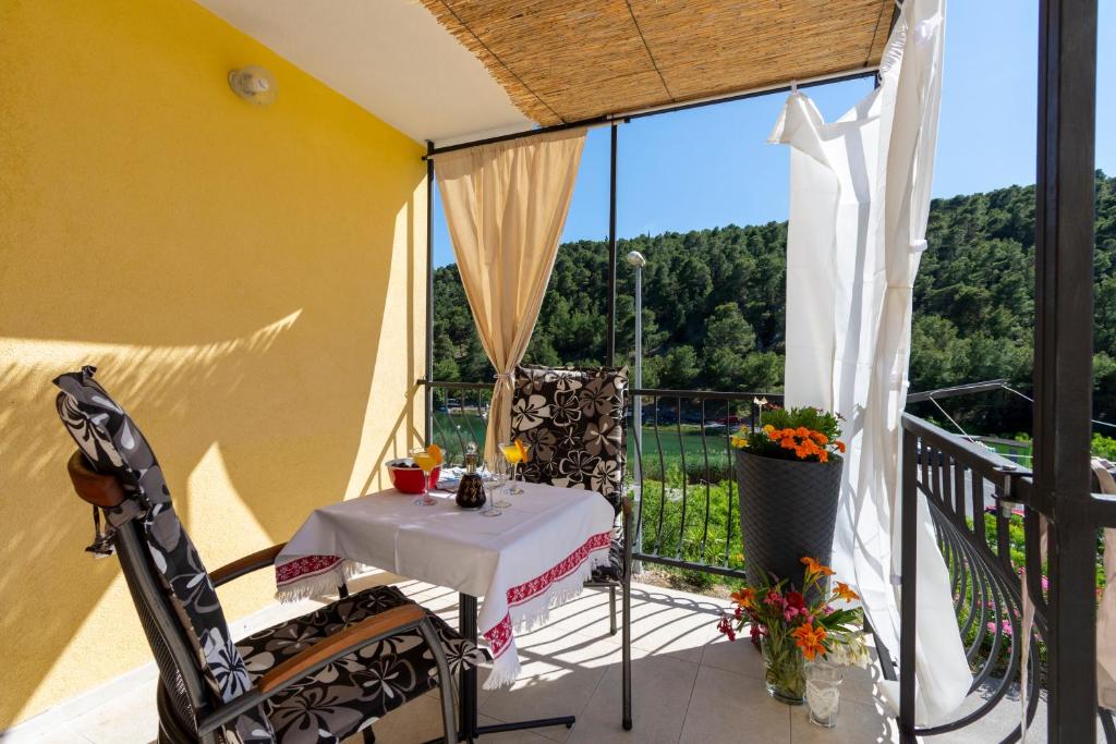 a table and chairs on a balcony with a view at Rokovača in Skradin