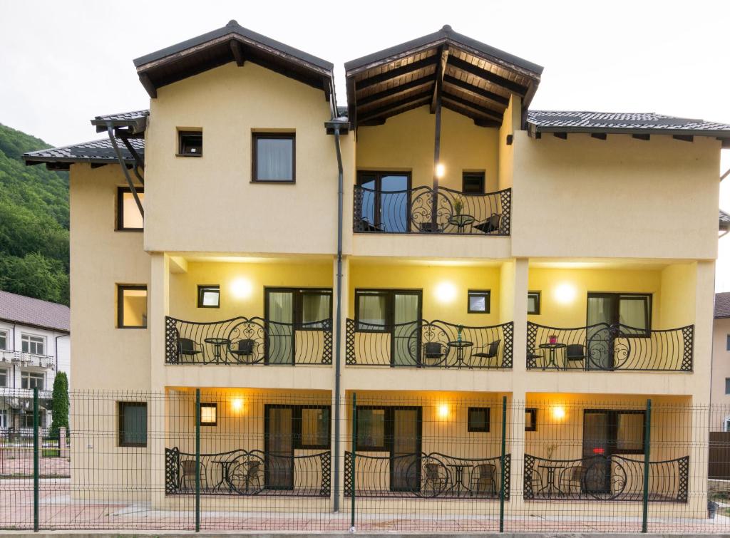 an apartment building with tables on the balconies at Vila Poienița Căciulata in Călimăneşti