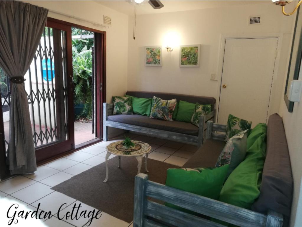 a living room with a couch and a table at Beach wood Cottages in Shelly Beach