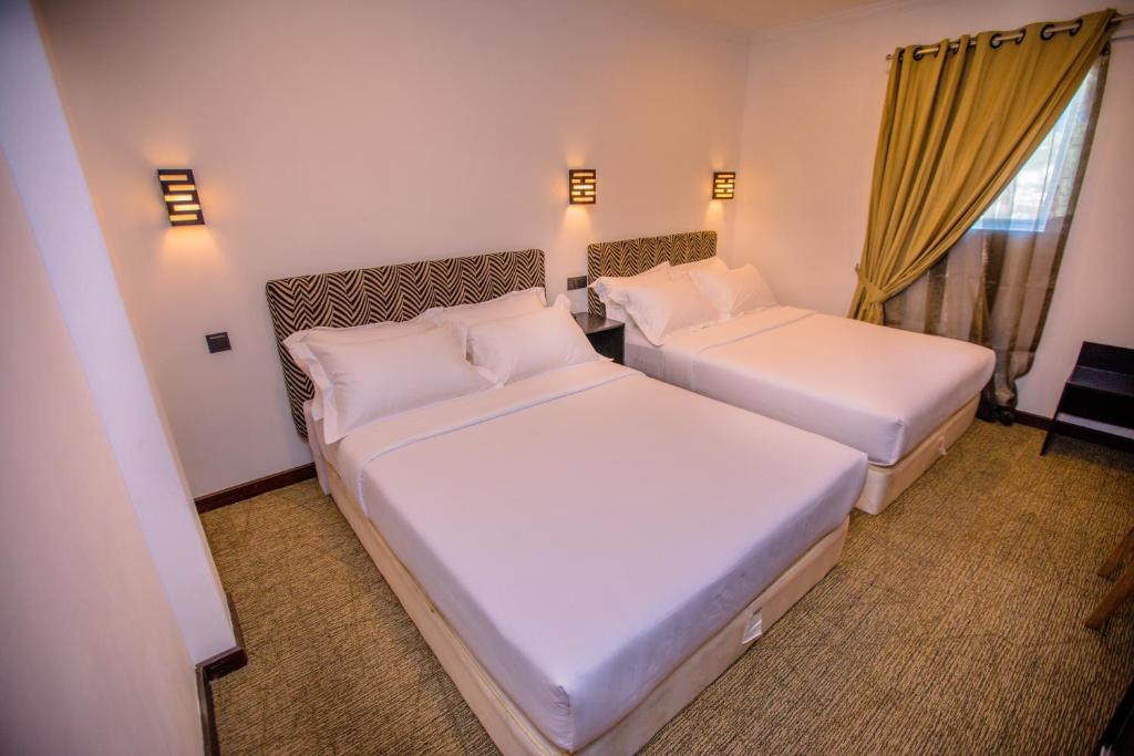 pokój hotelowy z 2 łóżkami i oknem w obiekcie Huddle w mieście Nuwara Eliya