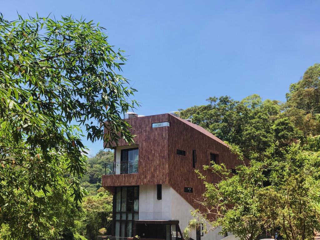 una casa con techo rojo y árboles en Siang Tsao Yu Chong en Sanyi