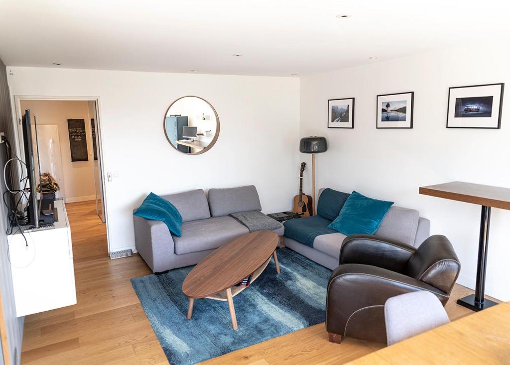 a living room with a couch and a table at Spacieux T2 remis à neuf, à 3 min des plages, terrasse in Anglet
