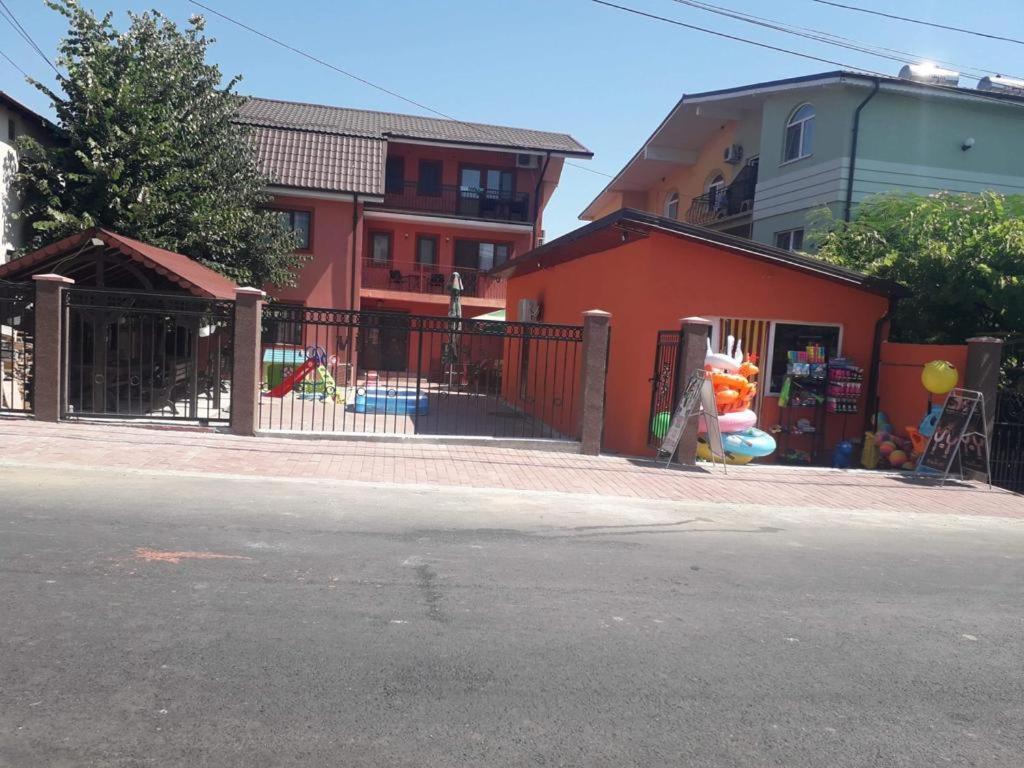 a playground in front of a building with a fence at Vila Dan in Costinesti