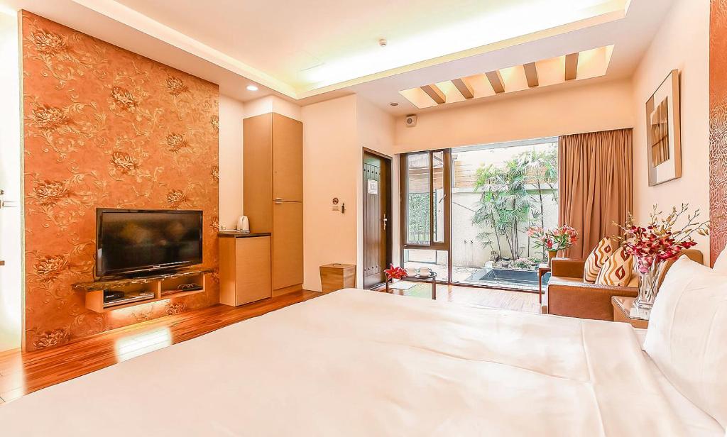 a large bedroom with a large bed and a television at Yage Hotspring House in Jiaoxi