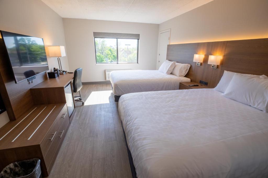 a hotel room with two beds and a television at Superior Stay Hotel in Marquette