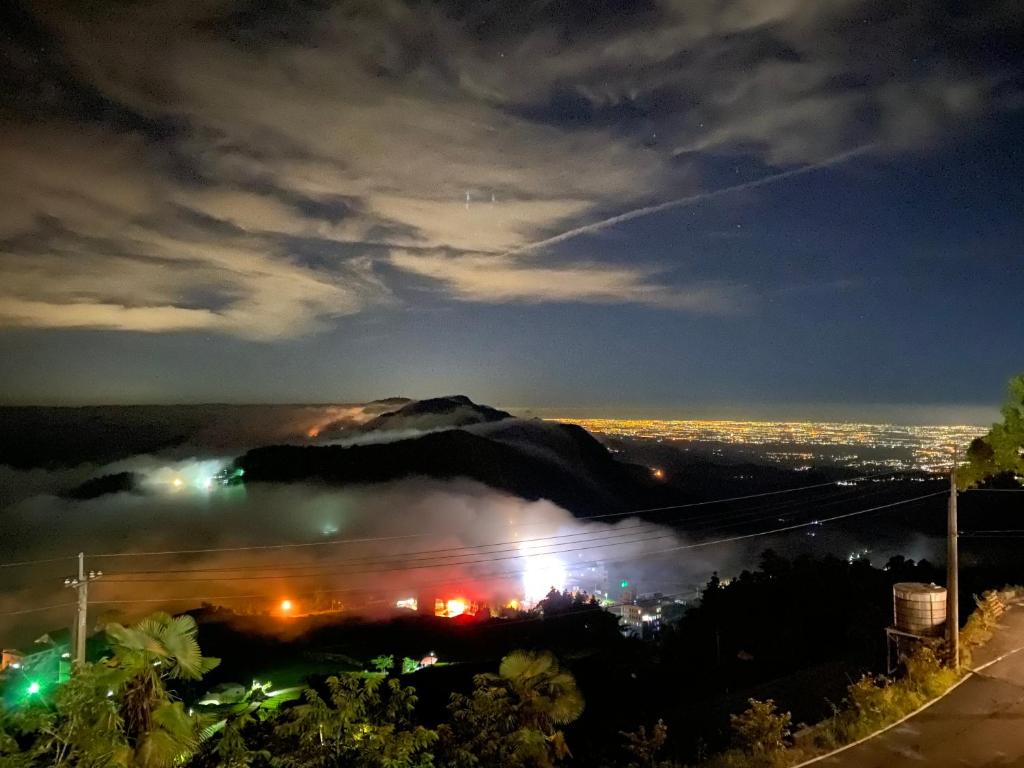 uma vista de uma cidade à noite com uma montanha em Siangting B&B em Fenqihu