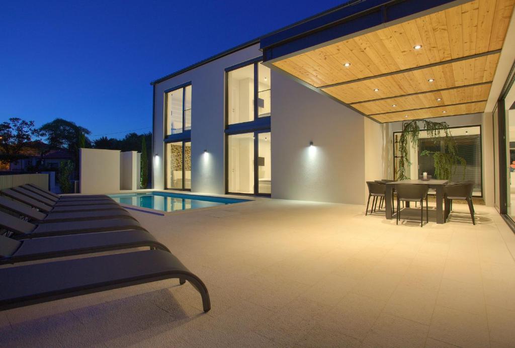 patio domu ze stołem i krzesłami w obiekcie Casa Bela w mieście Klimno