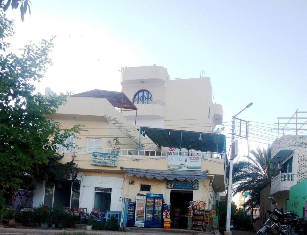a white building with a clock on top of it at Blue Sky Apartments in Luxor