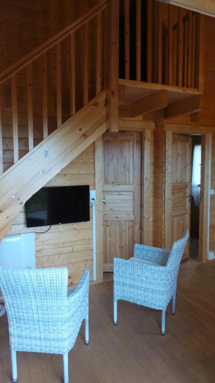 a living room with two chairs and a staircase at Chalet des Remparts in Sainte-Marie