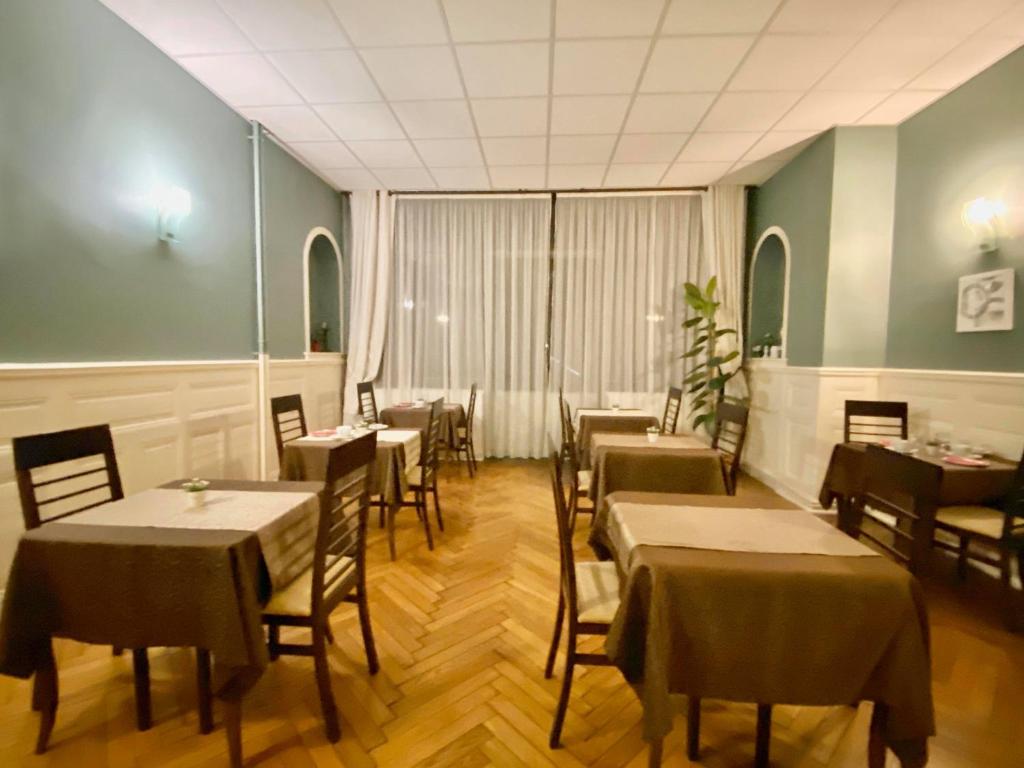 ein Restaurant mit Tischen und Stühlen in einem Zimmer in der Unterkunft Authentic by Balladins, Le Carré d'Aix in Aix-les-Bains