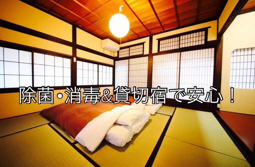Habitación con cama con escritura en la pared en Utatei, en Takayama