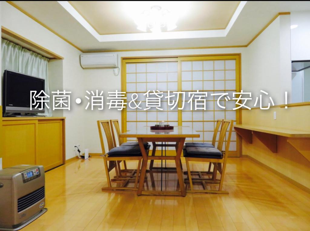 uma sala de jantar com mesa e cadeiras em Utatei Villa em Takayama