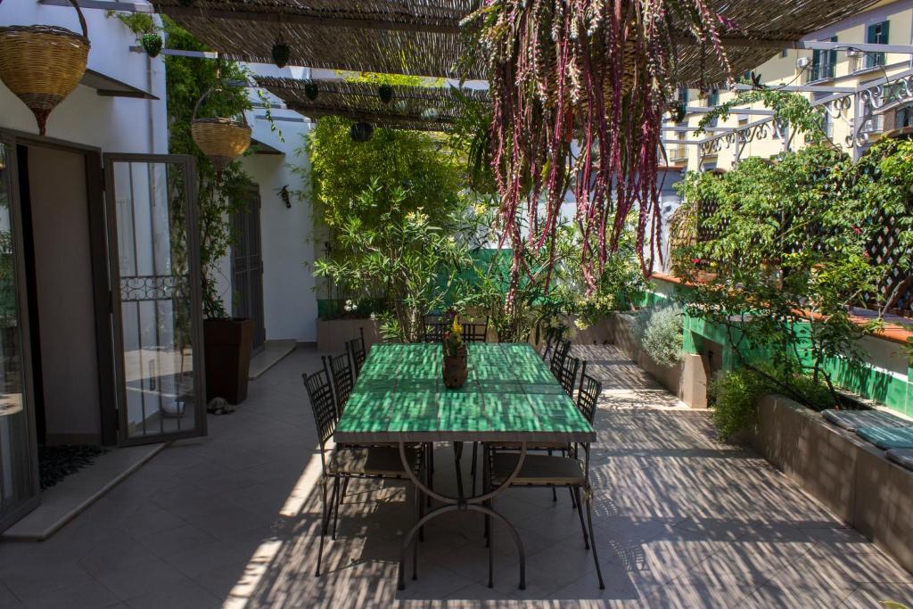 uma mesa verde e cadeiras num pátio em Cerasiello Apartment em Nápoles
