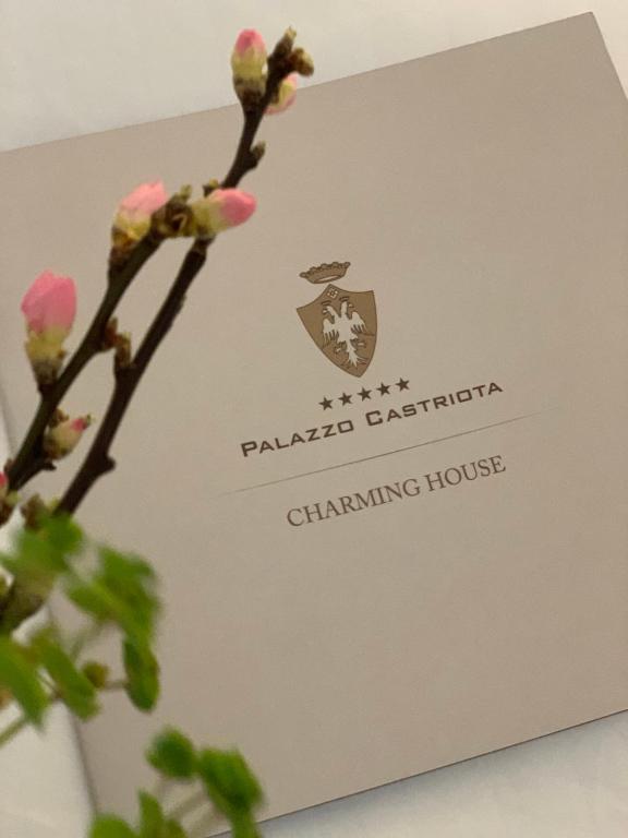 una tarjeta con una rama con flores rosas en Palazzo Castriota, en Alezio