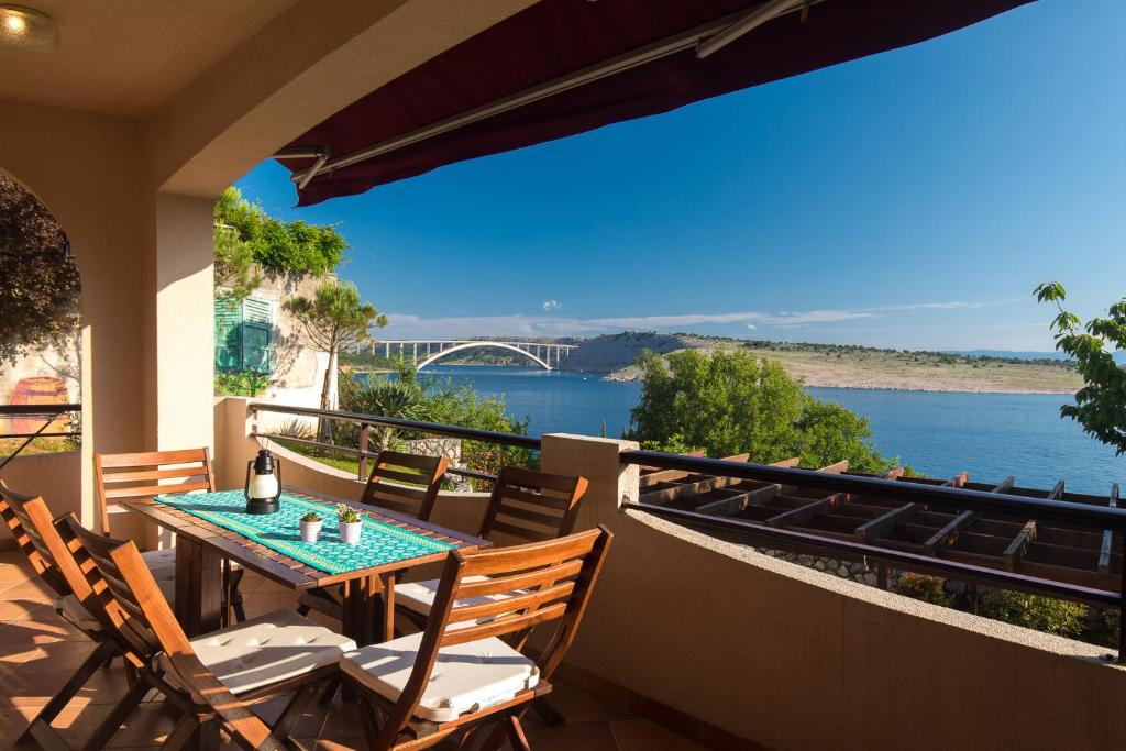 una mesa y sillas en un balcón con vistas al agua en Captain's Apartment with Sea View, en Kraljevica