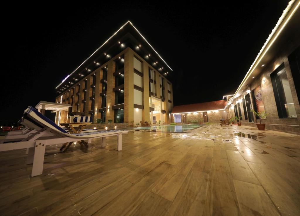 an empty parking lot in front of a building at night at Sarovar Portico, Somnath in Somnath