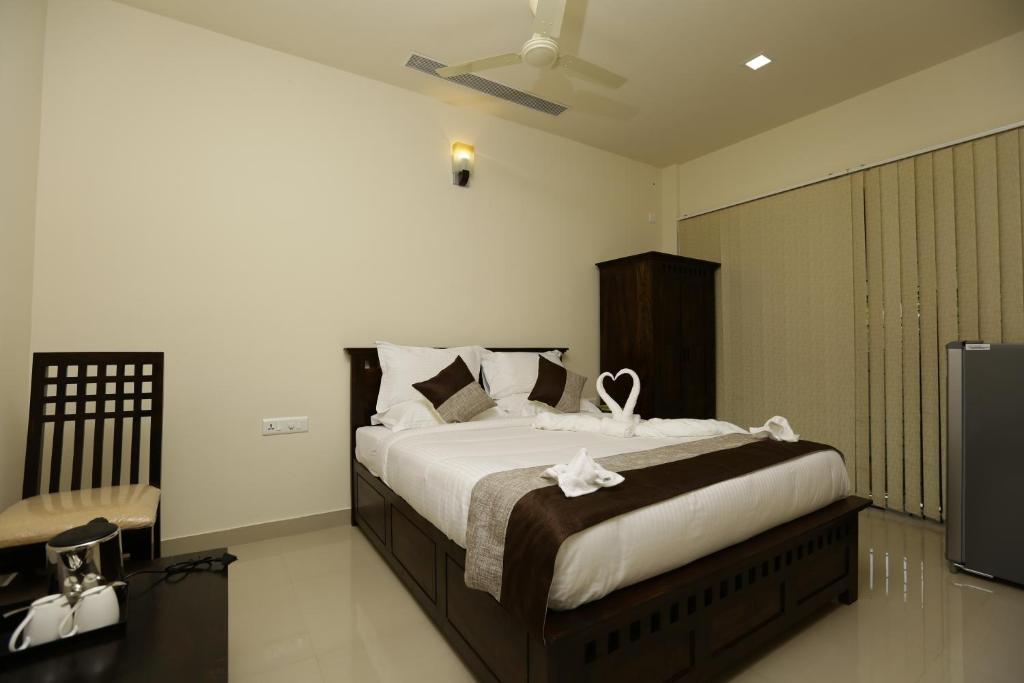 a bedroom with a large bed with white flowers on it at Le Noor in Ernakulam