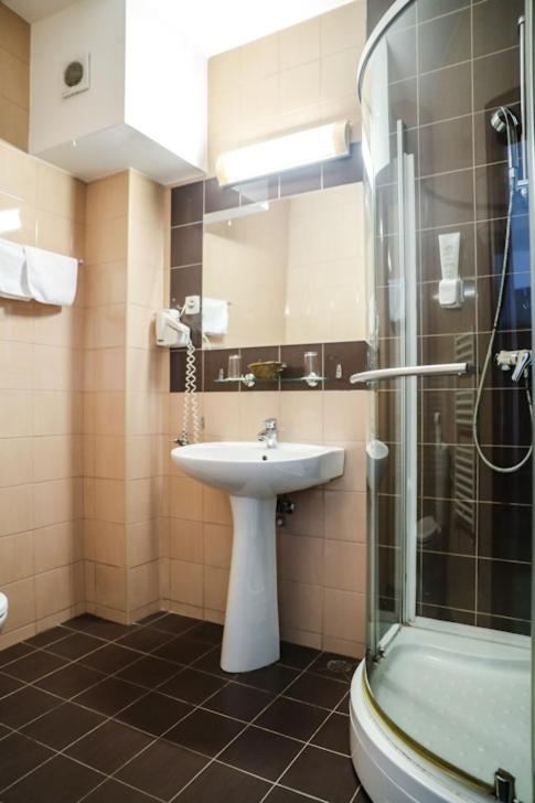 um banheiro com pia e chuveiro em Hotel Pami em Cluj-Napoca