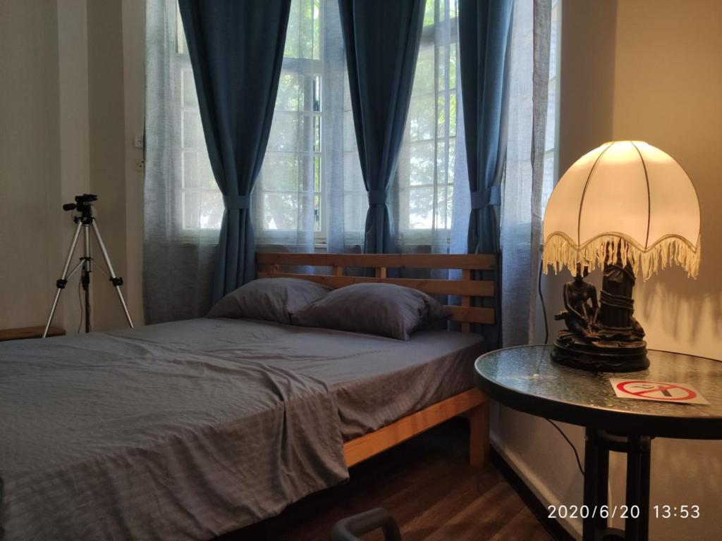 a bedroom with a bed and a table with a lamp at huge apartment near to Bahai Garden in Haifa