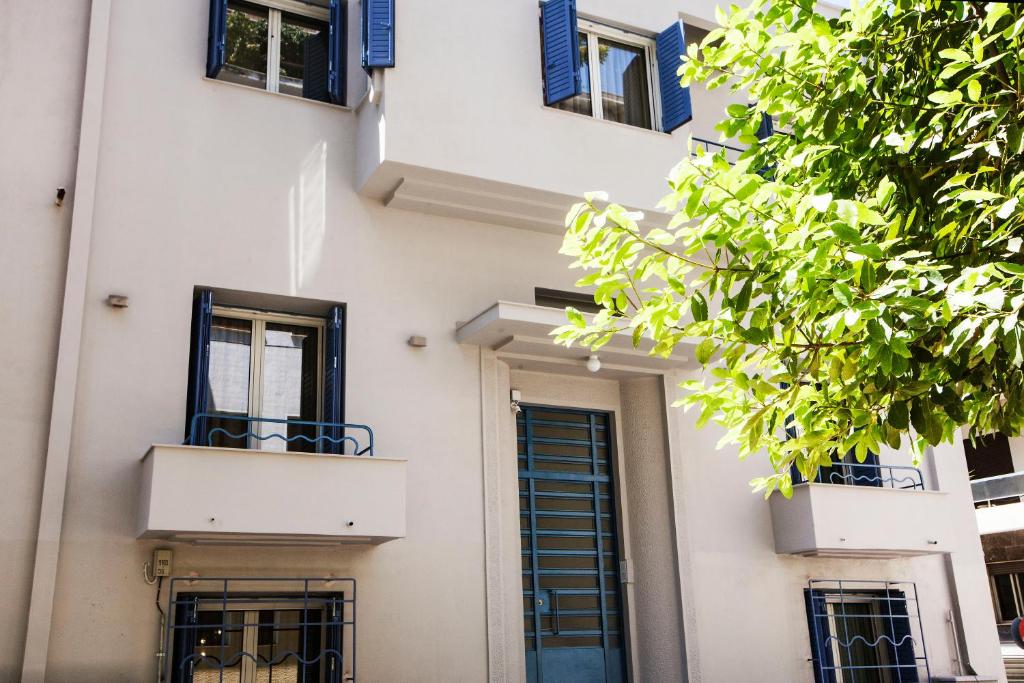 biały budynek z niebieskimi oknami i drzwiami w obiekcie Bentzi...Boutique Apartment 6, Superior Suite for 4 Guests w Atenach