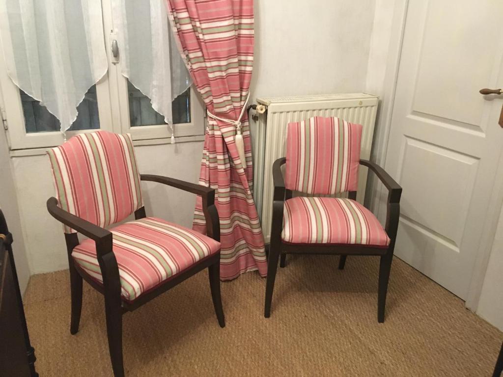 two chairs sitting in front of a window at Les Fleurs in Monpazier