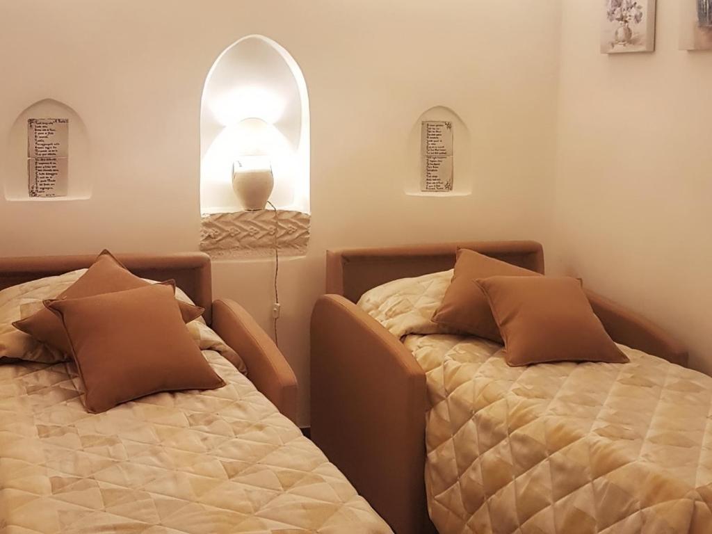 sypialnia z dwoma łóżkami i lustrem w obiekcie Il Centro Storico Ravello w mieście Ravello