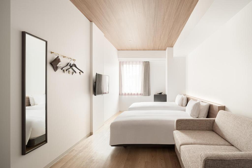 Postel nebo postele na pokoji v ubytování Nest Hotel Hiroshima Ekimae