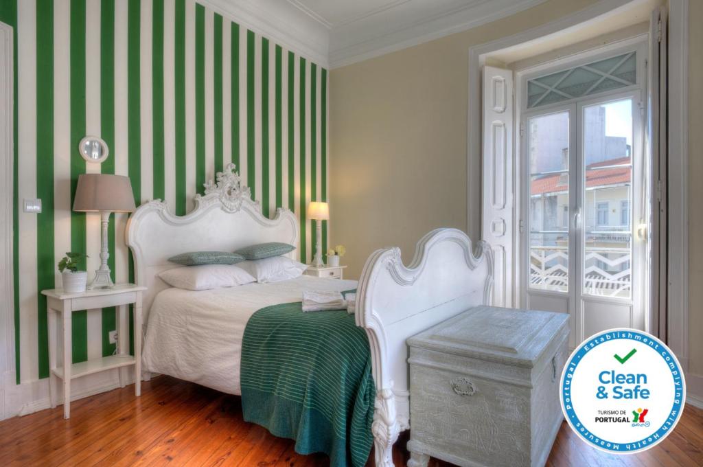 リスボンにあるAngola 1 - 6 Bedroomsの緑と白のストライプのベッド1台が備わるベッドルーム1室