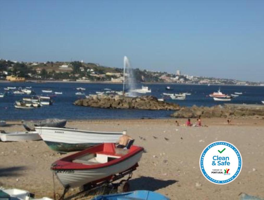 a group of boats sitting on a beach at Paço de Arcos Apartment in Paço de Arcos